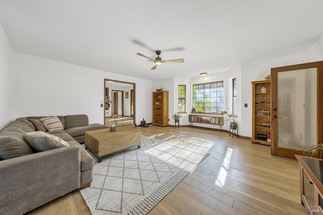 living room with ceiling fan and light hardwood / wood-style flooring