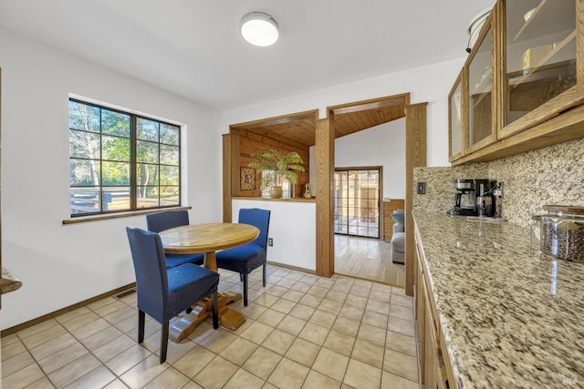 dining room featuring lofted ceiling and light tile patterned floors