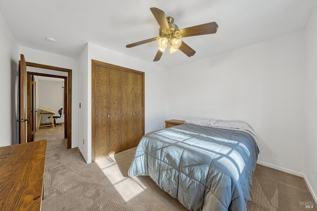 carpeted bedroom with ceiling fan and a closet