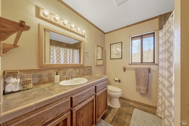 bathroom featuring toilet, vanity, decorative backsplash, and ornamental molding