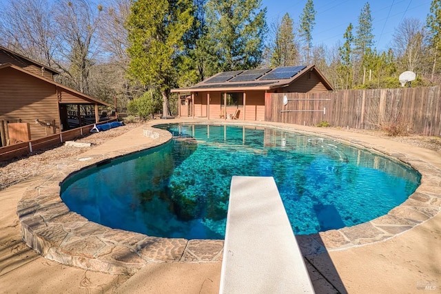 view of pool featuring a patio area and a diving board