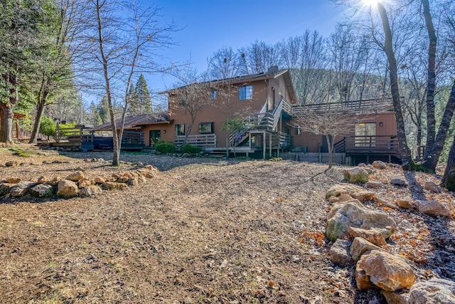 rear view of property featuring a wooden deck