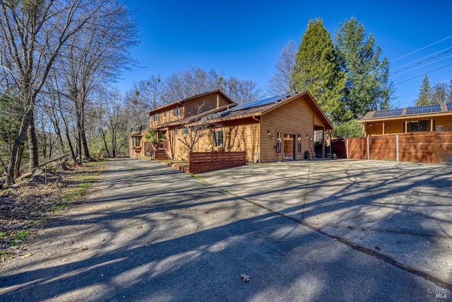 view of side of home featuring a garage and solar panels