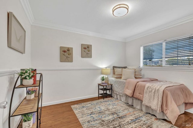 bedroom with hardwood / wood-style floors and crown molding