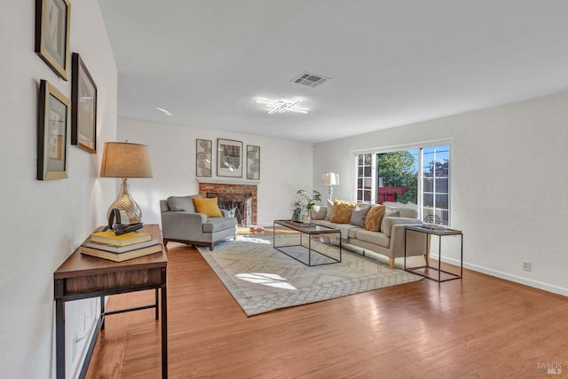 living room featuring wood-type flooring and a fireplace