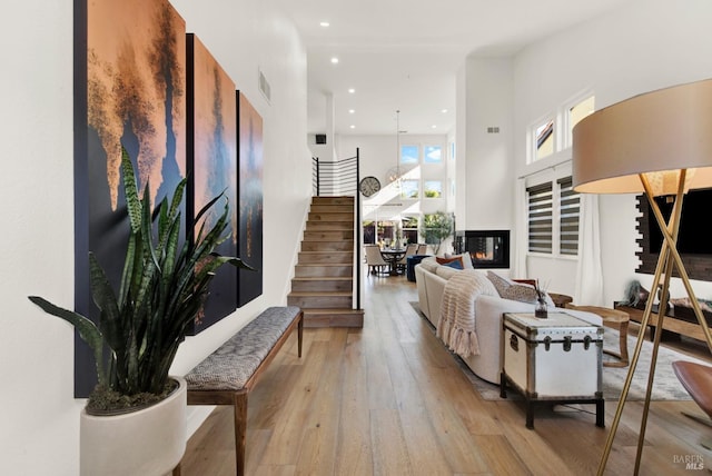 living room with a high ceiling and light hardwood / wood-style flooring