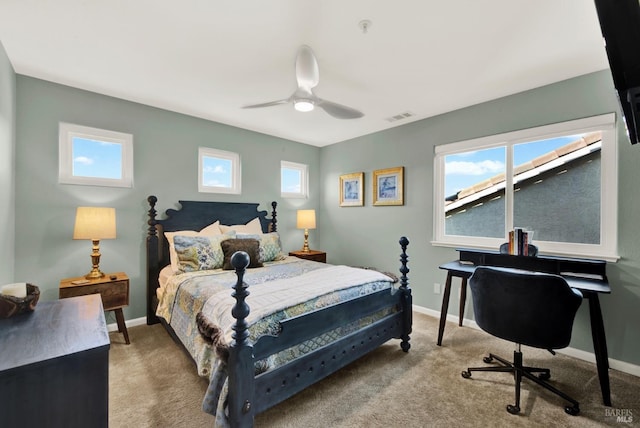 bedroom with multiple windows, light colored carpet, and ceiling fan