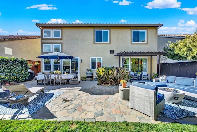 rear view of property with a pergola, a patio area, and an outdoor living space with a fire pit