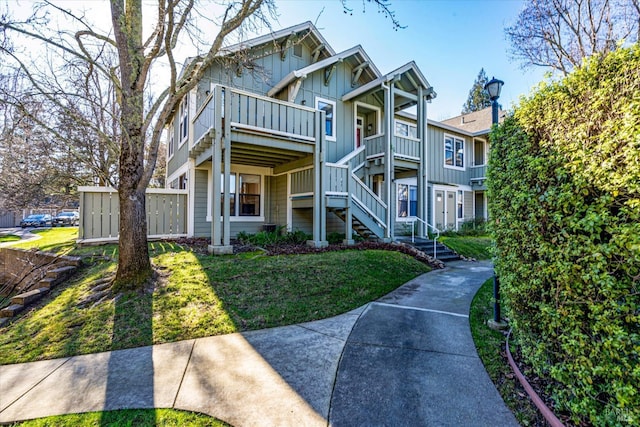 view of front of property with a balcony and a front yard