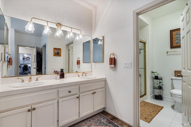 bathroom featuring toilet, tile patterned flooring, walk in shower, and vanity