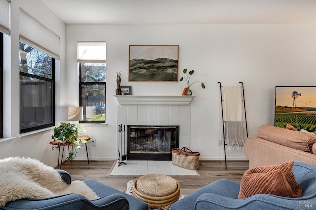 living room featuring light hardwood / wood-style flooring and a tiled fireplace