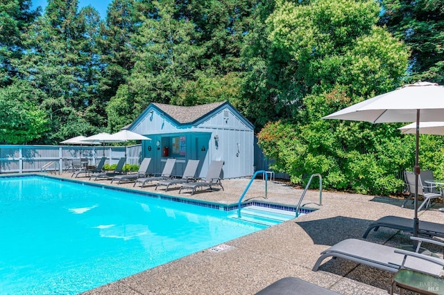 view of swimming pool featuring an outdoor structure and a patio