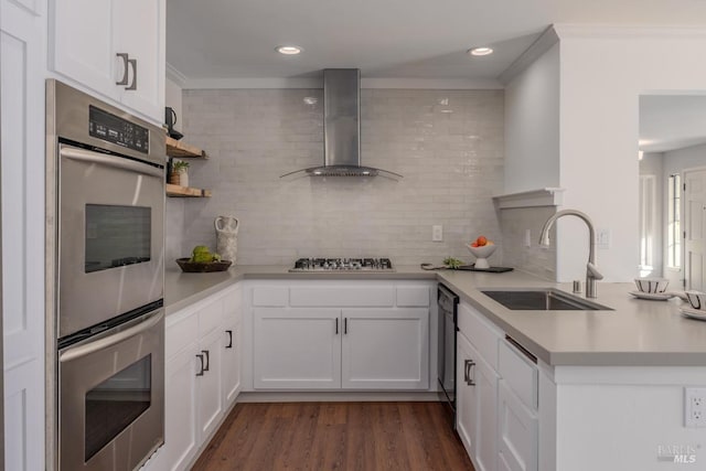 kitchen with decorative backsplash, wall chimney exhaust hood, white cabinets, and sink