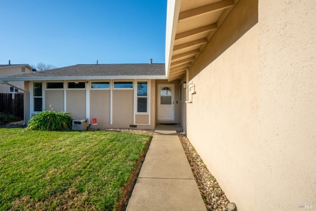 doorway to property featuring a lawn