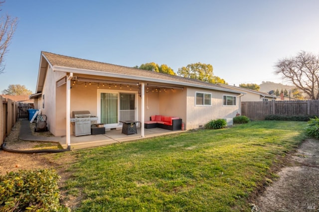 back of property with a patio area and a yard