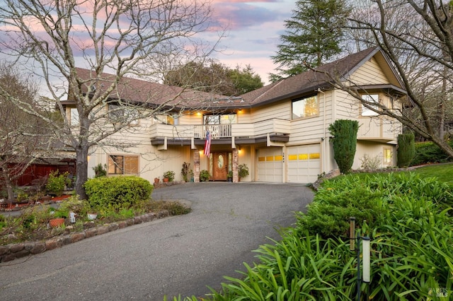 view of front of property featuring a balcony and a garage