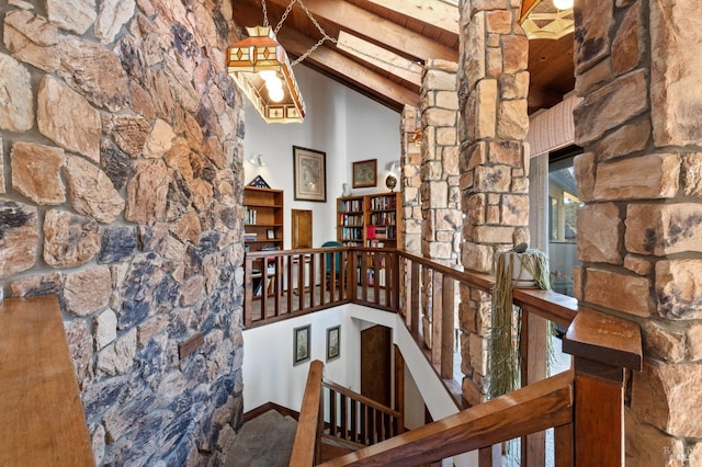 hall featuring high vaulted ceiling and beam ceiling