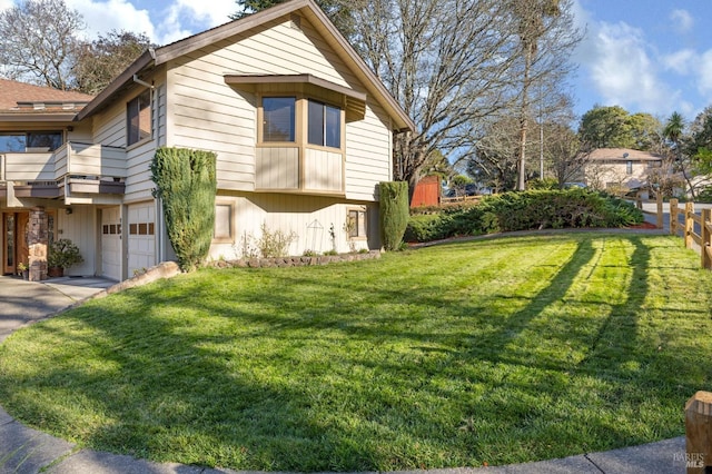 view of property exterior featuring a balcony, a garage, and a yard