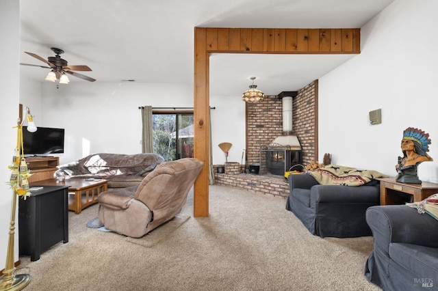 carpeted living room with ceiling fan and a wood stove