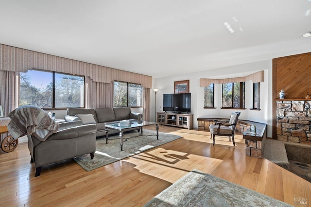 living room featuring light hardwood / wood-style floors, plenty of natural light, and wooden walls