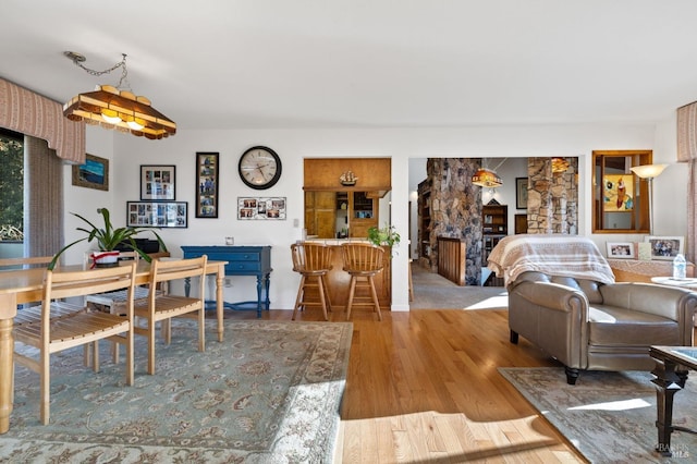 dining space featuring light hardwood / wood-style flooring and a stone fireplace