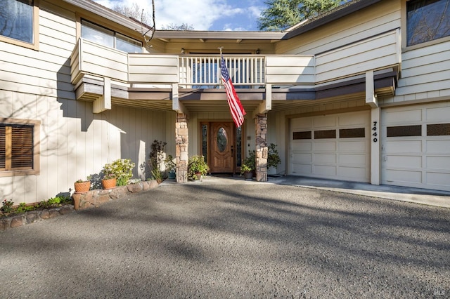 entrance to property featuring a garage and a balcony