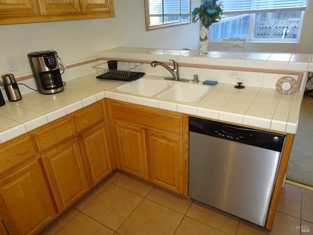 kitchen featuring light tile patterned flooring, tile countertops, dishwasher, and sink