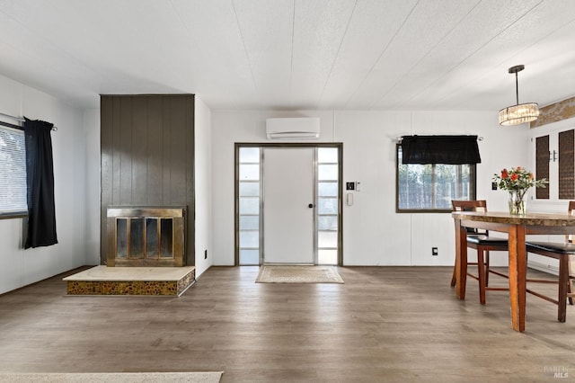 foyer featuring a fireplace, hardwood / wood-style flooring, and a wall mounted AC