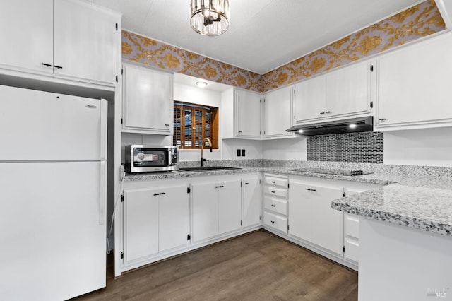 kitchen with sink, dark wood-type flooring, white cabinetry, black electric cooktop, and white fridge