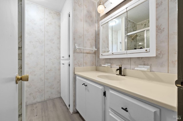 bathroom featuring hardwood / wood-style flooring, an enclosed shower, and vanity