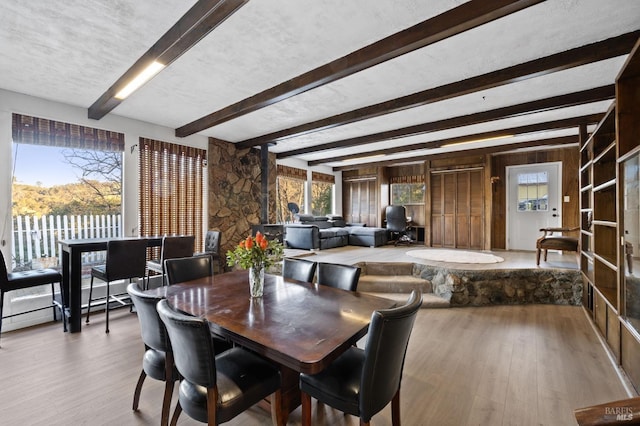 dining room featuring hardwood / wood-style floors and beam ceiling