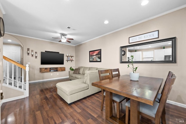 dining area featuring dark wood-style floors, arched walkways, visible vents, and crown molding