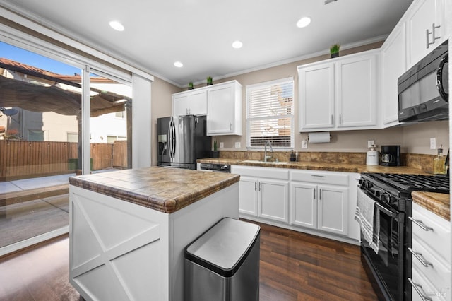 kitchen featuring black appliances, white cabinetry, and a sink