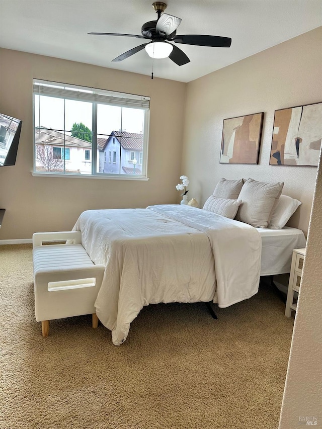 carpeted bedroom with baseboards and a ceiling fan