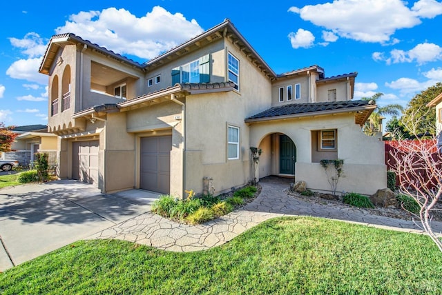 mediterranean / spanish house featuring a garage and a front lawn