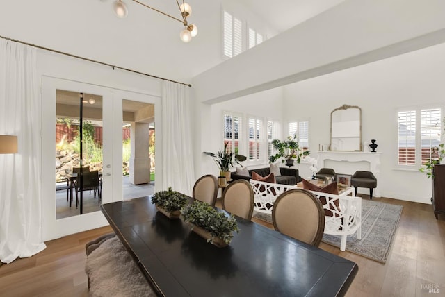 dining area with french doors, a chandelier, and hardwood / wood-style floors