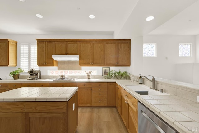 kitchen featuring tile counters, light hardwood / wood-style floors, sink, gas stovetop, and stainless steel dishwasher