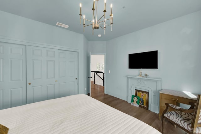 bedroom featuring dark wood-type flooring, a closet, and a chandelier