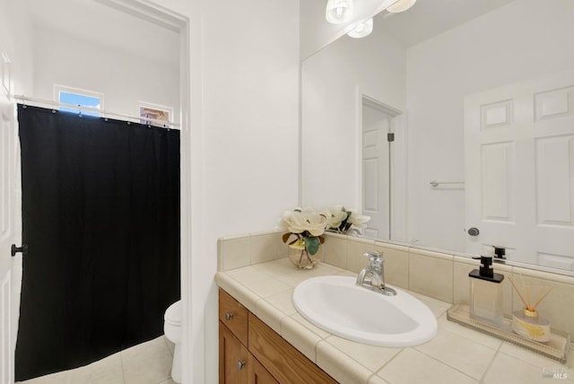 bathroom featuring toilet, tile patterned flooring, and vanity