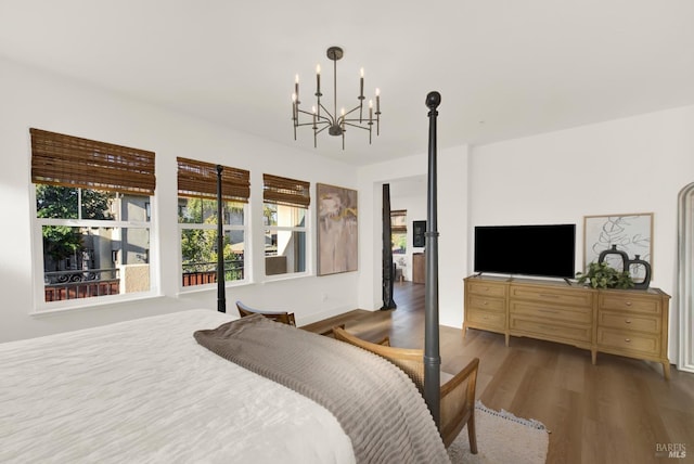 bedroom with wood-type flooring and an inviting chandelier