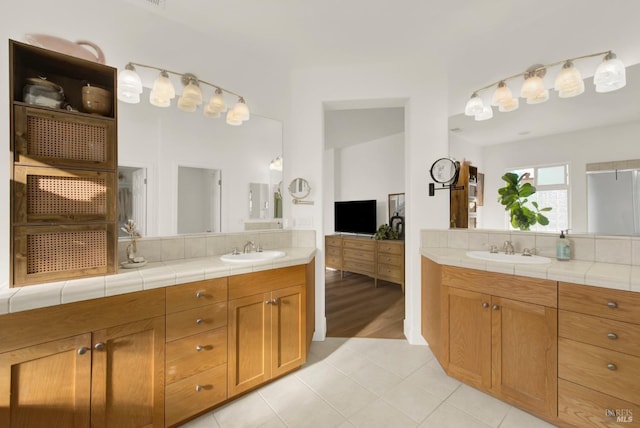 bathroom featuring tile patterned flooring, tasteful backsplash, and vanity