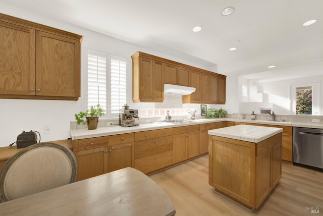 kitchen with a center island, dishwasher, tile countertops, and light hardwood / wood-style floors