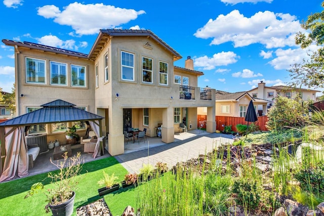 back of house featuring central AC unit, a gazebo, outdoor lounge area, a balcony, and a patio