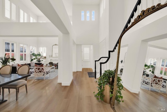 entrance foyer with a towering ceiling and light hardwood / wood-style flooring