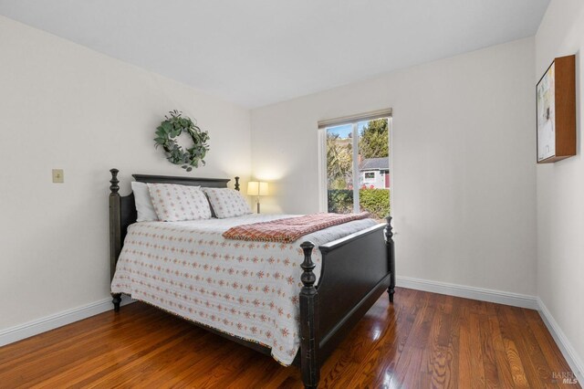 bedroom with dark wood-type flooring