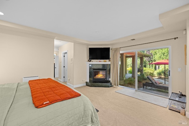 carpeted bedroom featuring a fireplace and access to outside