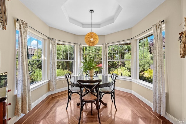 sunroom featuring plenty of natural light and a raised ceiling