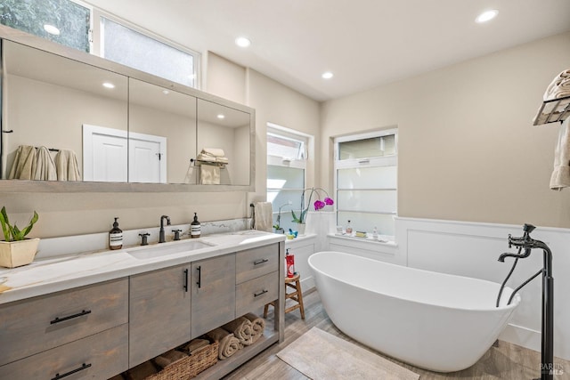 bathroom featuring a bath, hardwood / wood-style flooring, and vanity