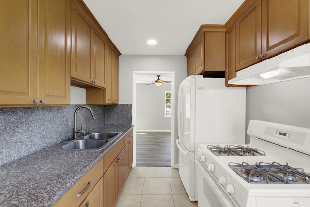 kitchen with sink, decorative backsplash, light tile patterned floors, ceiling fan, and white gas stove