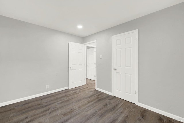 unfurnished room with dark wood-type flooring